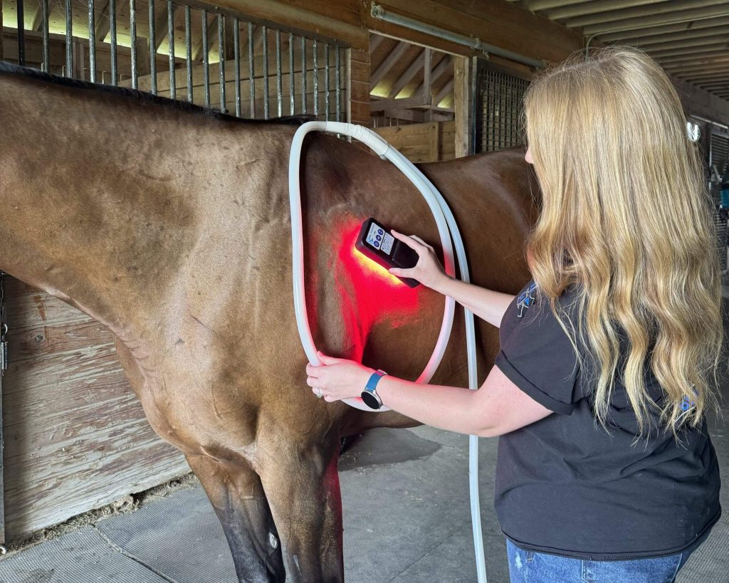 A woman applying dual modalities of ROC Red Light therapy and PEMF therapy via the MagnaWavePEMF XL Wave Wings attachment